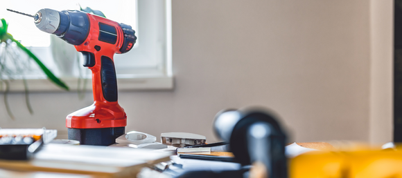 Power tools on a table in front of a window.